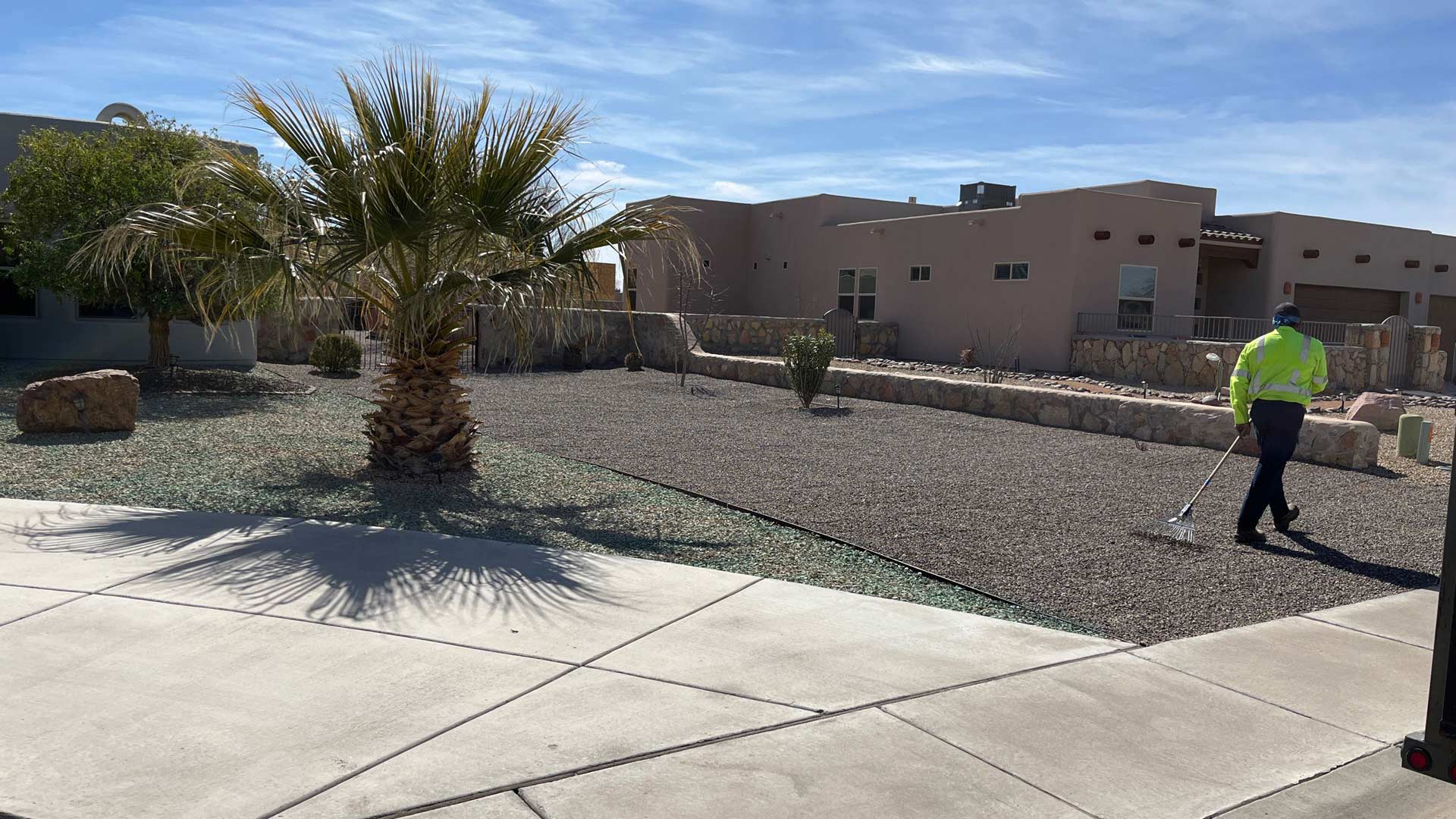 Extreme Landscaping's crew member in landscape raking rock installed in Mesilla, NM.