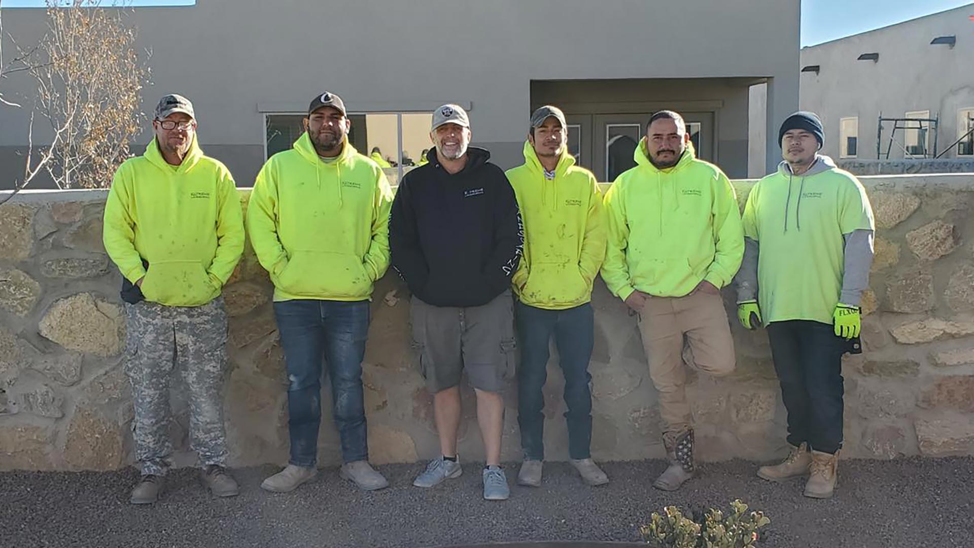 Crew members standing along a retaining wall.
