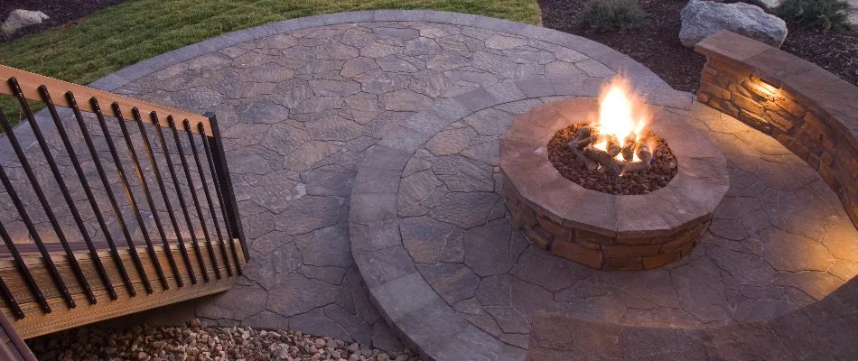 Burning fire pit on a patio next to a seating wall in Las Cruces, NM.