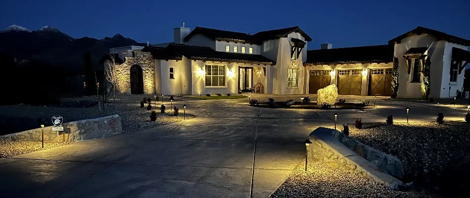 A property in Fairacres, NM, lit up with outdoor lighting.