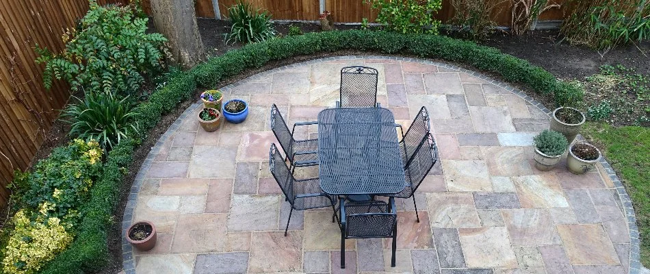 Round fire pit in Alamogordo, NM, with plants and furniture.