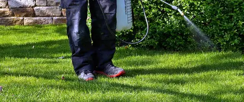 Spraying a clients lawn with post emergent weed killer.